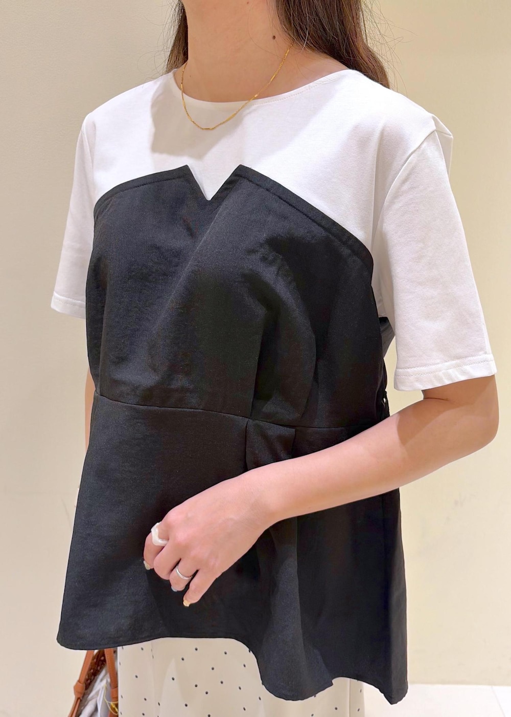 ブラック系のパンプス、ブラウン系のショルダーバッグ、ホワイト系のスカートを着用したレディースの春コーディネートの6枚目の写真