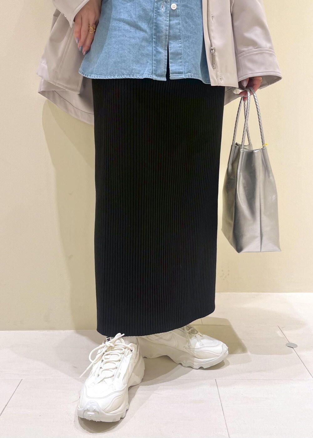 シルバー系のトートバッグ、ブラック系のスカート、ブルー系のシャツ/ブラウスを着用したレディースの春コーディネートの7枚目の写真