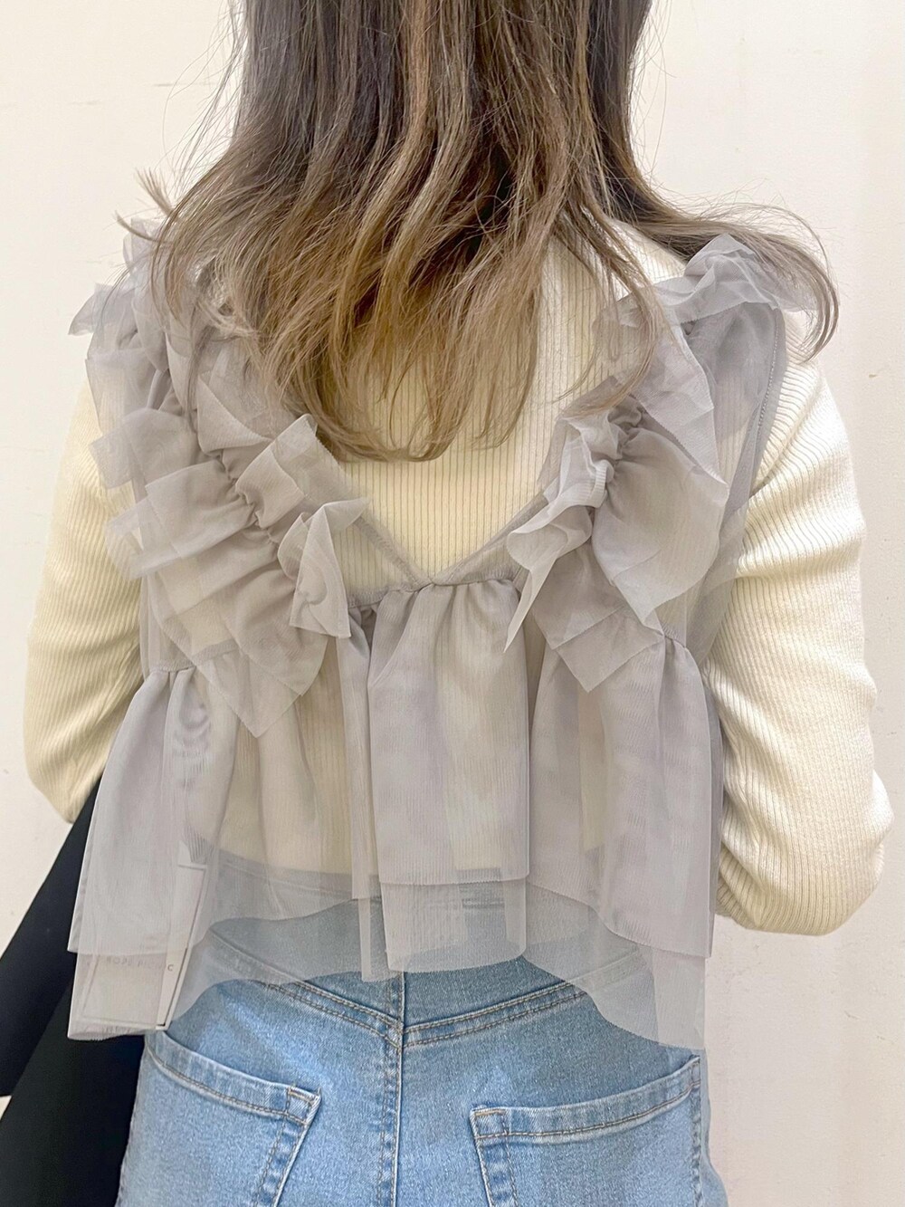 ブルー系のデニムパンツ、レッド系のトートバッグ、ブラック系のその他アウターを着用したレディースの冬コーディネートの6枚目の写真