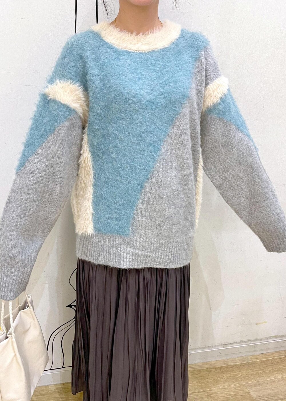 ブラック系のブーツ、ブルー系のニット/セーター、ブラウン系のスカートを着用したレディースの秋コーディネートの6枚目の写真