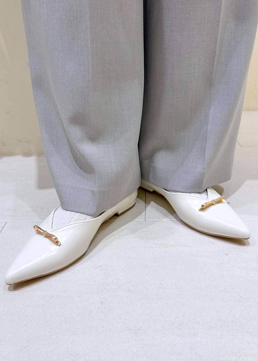 ベージュ系のショルダーバッグ、ホワイト系のキャミソール、ブラウン系のカーディガン/ボレロを着用したレディースの春コーディネートの9枚目の写真