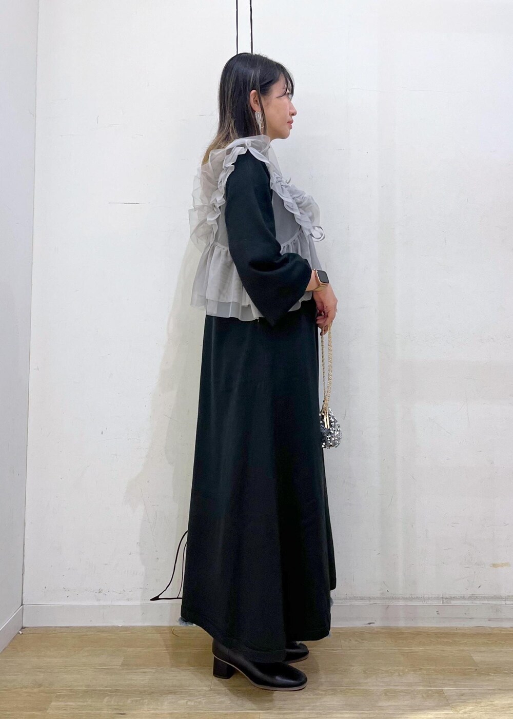 ブルー系のデニムスカート、ブラック系のブーツ、ブラック系のワンピースを着用したレディースの冬コーディネートの3枚目の写真