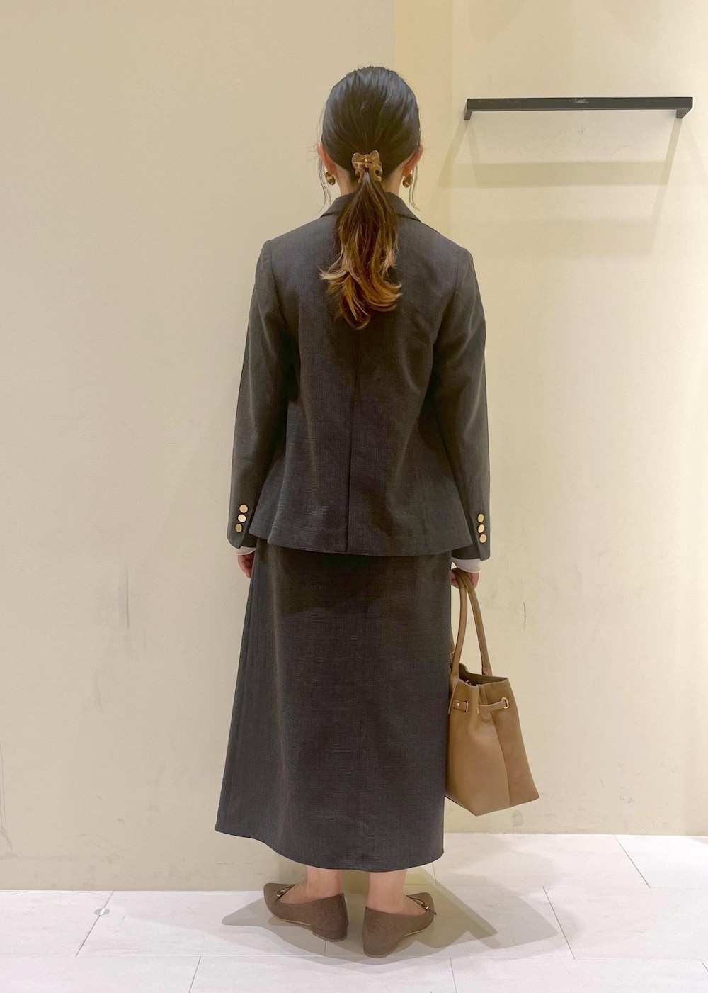 ブラック系のスカート、ブラック系のテーラードジャケット、ホワイト系のTシャツ/カットソーを着用したレディースの秋コーディネートの4枚目の写真