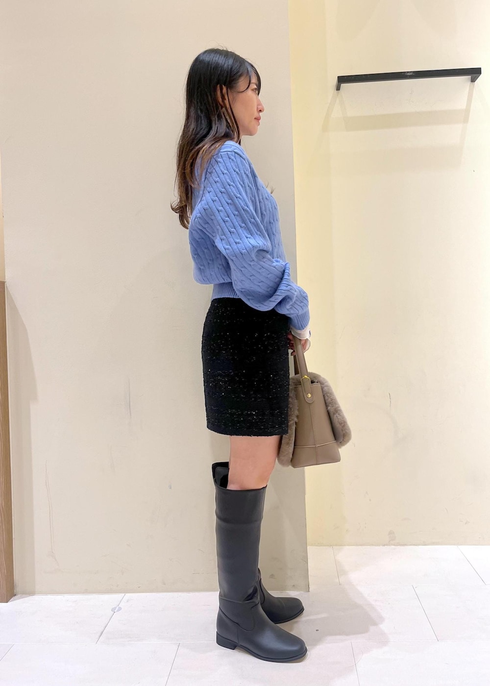 ブルー系のスカート、ホワイト系のTシャツ/カットソー、ブルー系のニット/セーターを着用したレディースの冬コーディネートの2枚目の写真