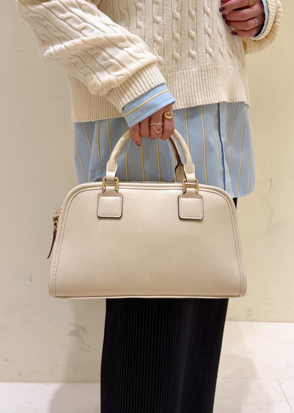 ホワイト系のニット/セーター、ブラック系のローファー、ホワイト系のボストンバッグを着用したレディースの冬コーディネートの7枚目の写真