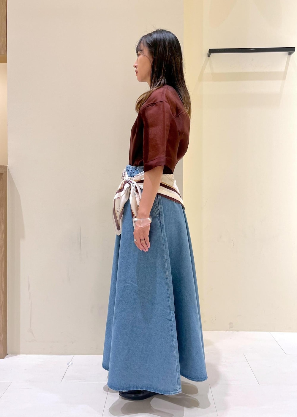 ブラック系のトートバッグ、ブラウン系のシャツ/ブラウス、ブルー系のスカートを着用したレディースの秋コーディネートの5枚目の写真