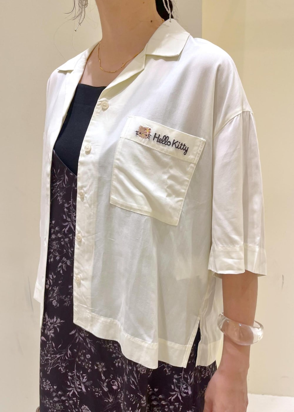 ブラウン系のトートバッグ、ゴールド系のサンダル、ブラック系のワンピースを着用したレディースの夏コーディネートの6枚目の写真