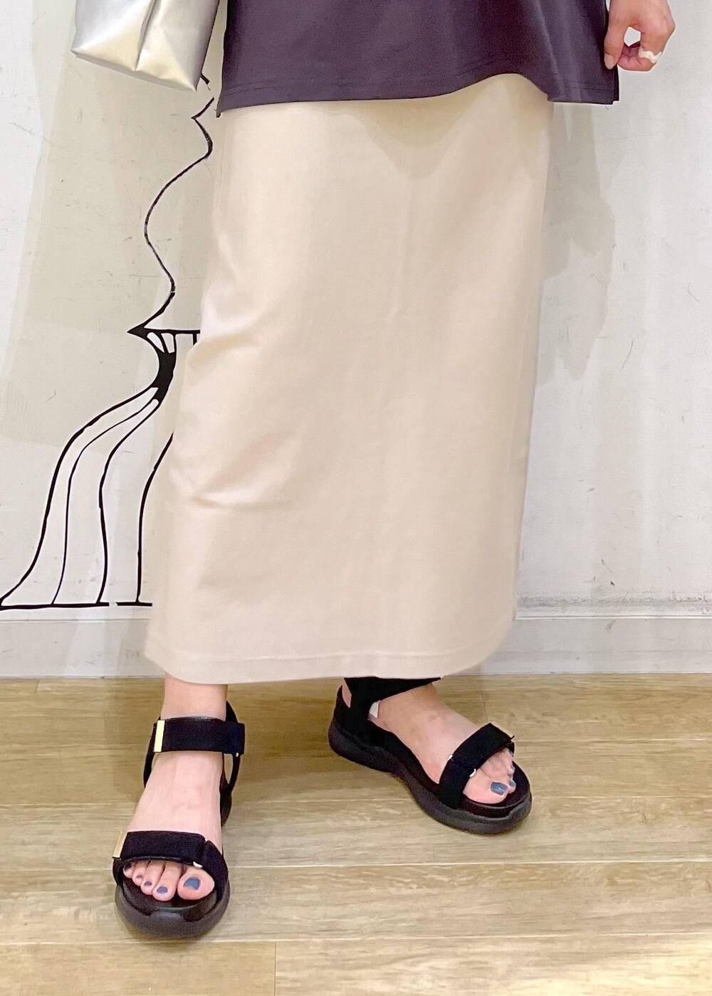 シルバー系のトートバッグ、ブラック系のサンダル、グレー系のTシャツ/カットソーを着用したレディースの夏コーディネートの6枚目の写真