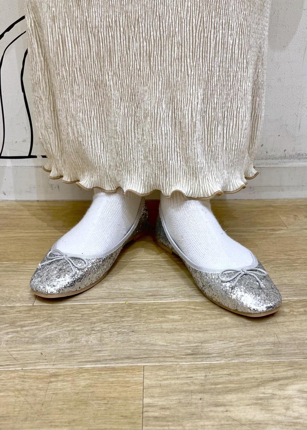 ベージュ系のハンドバッグ、ホワイト系のニット/セーター、シルバー系のバレエシューズを着用したレディースの冬コーディネートの9枚目の写真