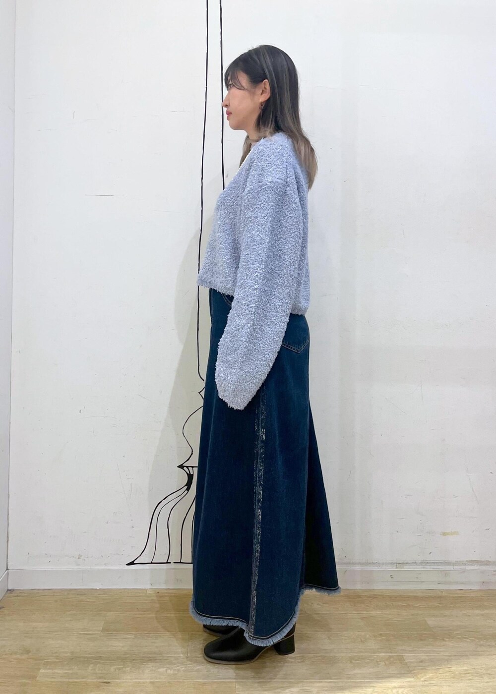 ブラック系のブーツ、グレー系のショルダーバッグ、ブルー系のデニムスカートを着用したレディースの冬コーディネートの4枚目の写真