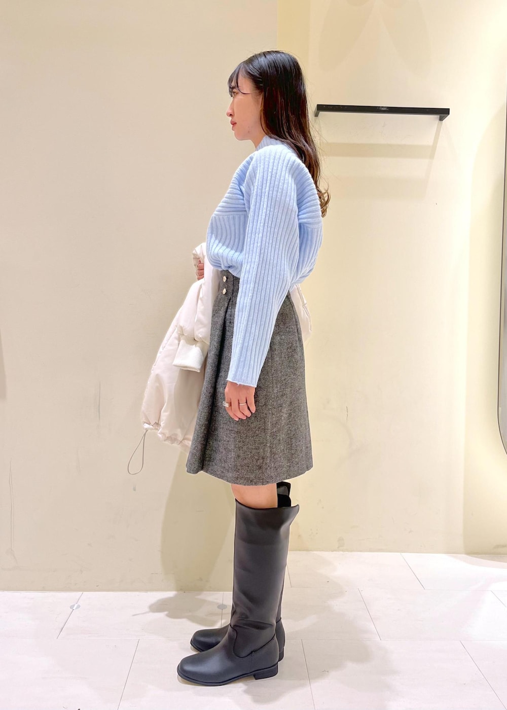 ブラック系のブーツ、ブラウン系のショルダーバッグ、ブルー系のニット/セーターを着用したレディースの冬コーディネートの4枚目の写真