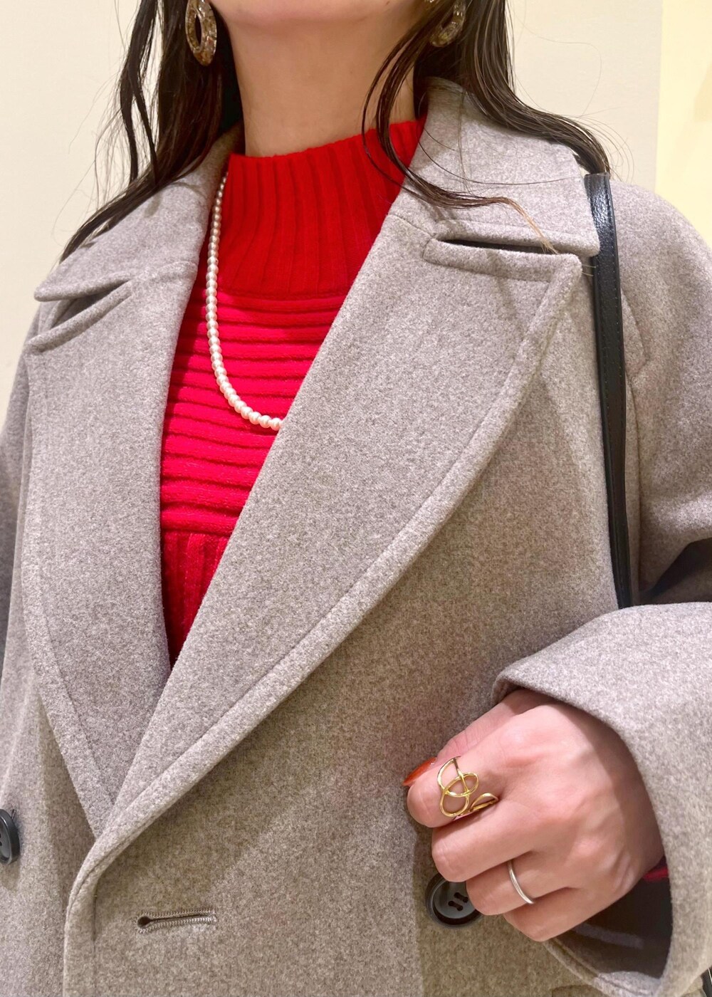 ブラック系のショルダーバッグ、レッド系のニット/セーター、ブラウン系のピーコートを着用したレディースの秋コーディネートの5枚目の写真