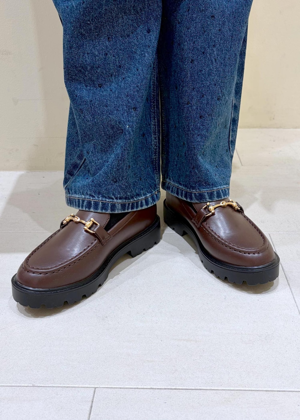 ブルー系のデニムパンツ、ブラウン系のローファー、ブラック系のトートバッグを着用したレディースの秋コーディネートの10枚目の写真