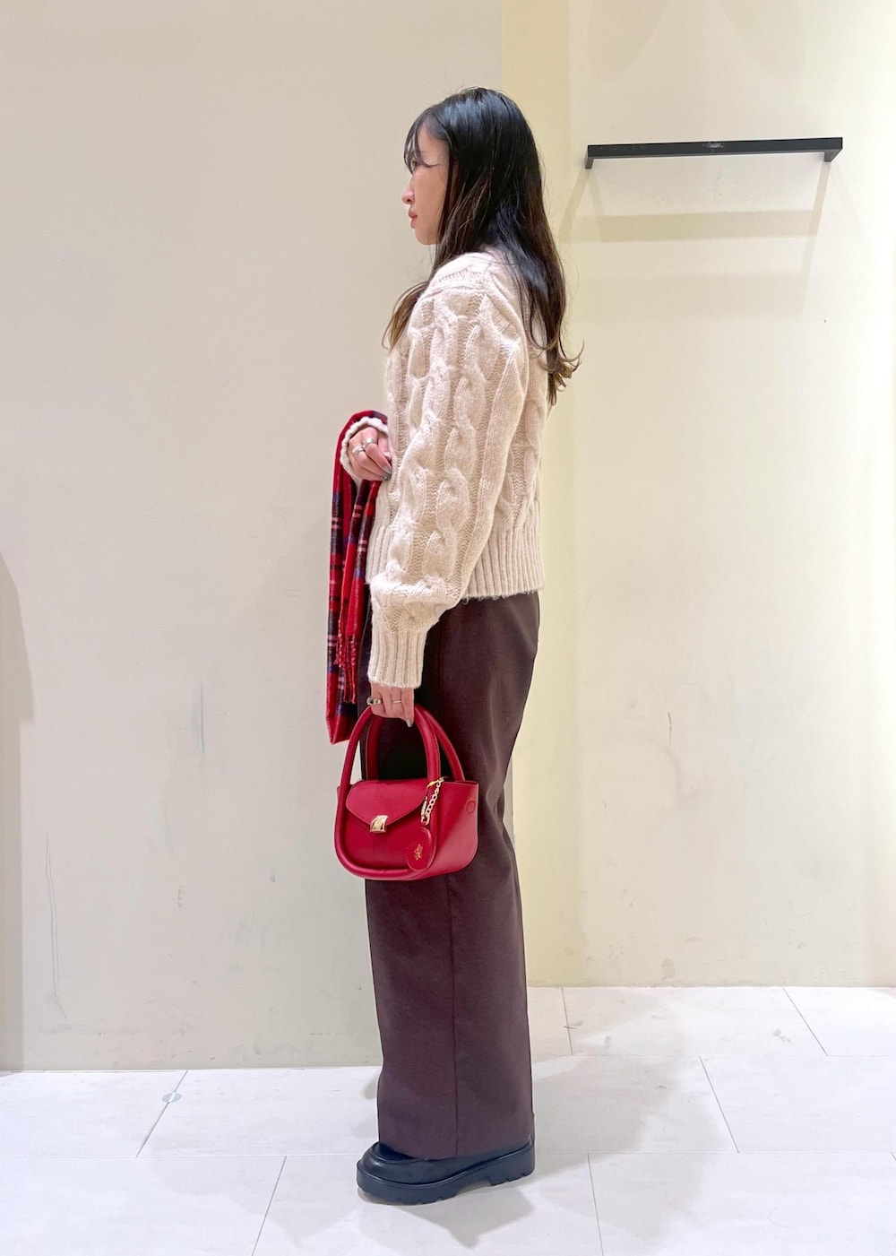 ホワイト系のニット/セーター、レッド系のショルダーバッグ、ブラック系のローファーを着用したレディースの冬コーディネートの4枚目の写真