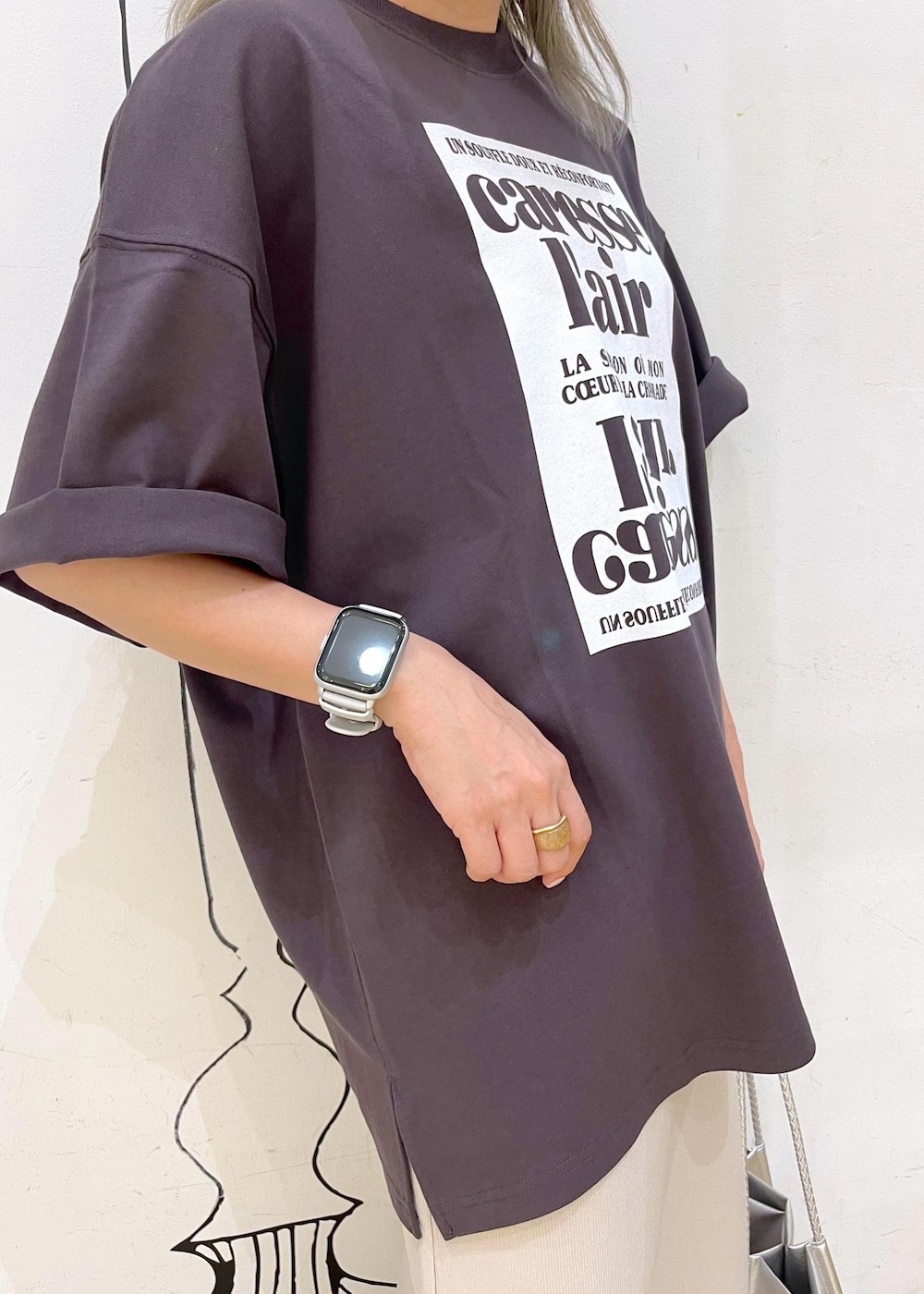 シルバー系のトートバッグ、ブラック系のサンダル、グレー系のTシャツ/カットソーを着用したレディースの夏コーディネートの5枚目の写真