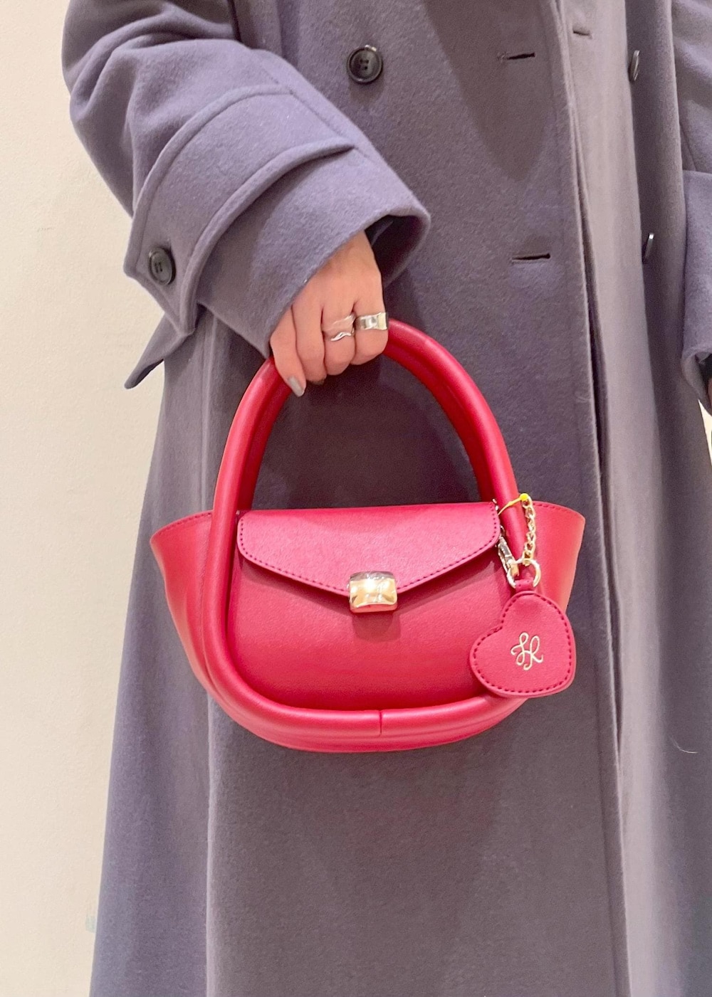 ホワイト系のニット/セーター、グレー系のチェスターコート、レッド系のショルダーバッグを着用したレディースの冬コーディネートの8枚目の写真