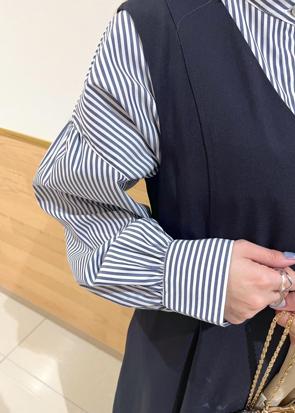 グレー系のショルダーバッグ、ブルー系のシャツ/ブラウス、ベージュ系のトレンチコートを着用したレディースの冬コーディネートの7枚目の写真