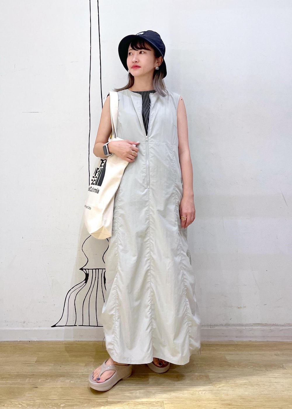 ホワイト系のトートバッグ、ブラック系のTシャツ/カットソー、グレー系のワンピースを着用したレディースの夏コーディネートの3枚目の写真