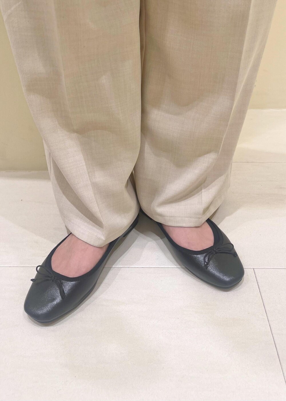 ブラック系のハンドバッグ、ブルー系のベスト、イエロー系のシャツ/ブラウスを着用したレディースの春コーディネートの10枚目の写真