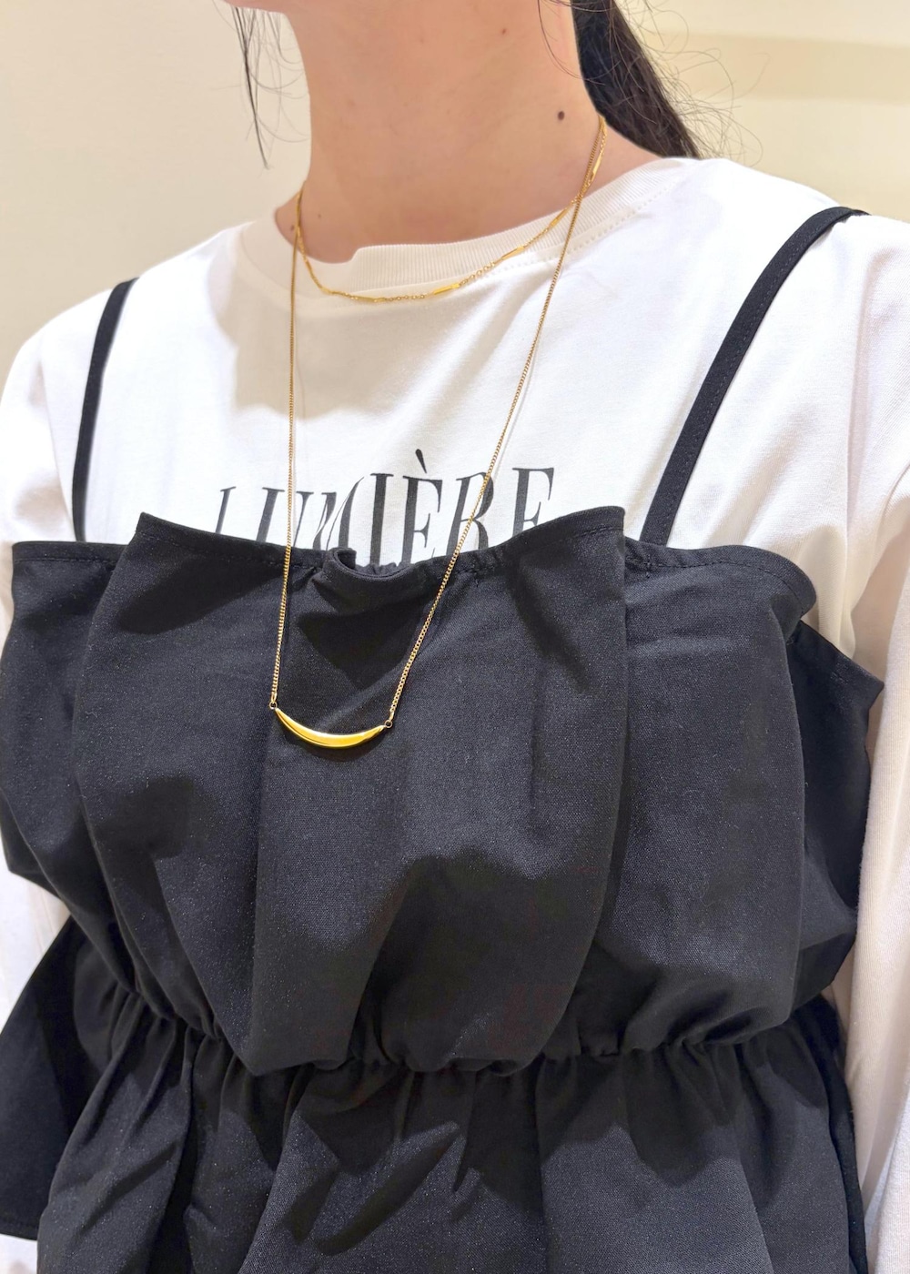 ブラウン系のスカート、ホワイト系のTシャツ/カットソー、ブラック系のキャミソールを着用したレディースの秋コーディネートの6枚目の写真