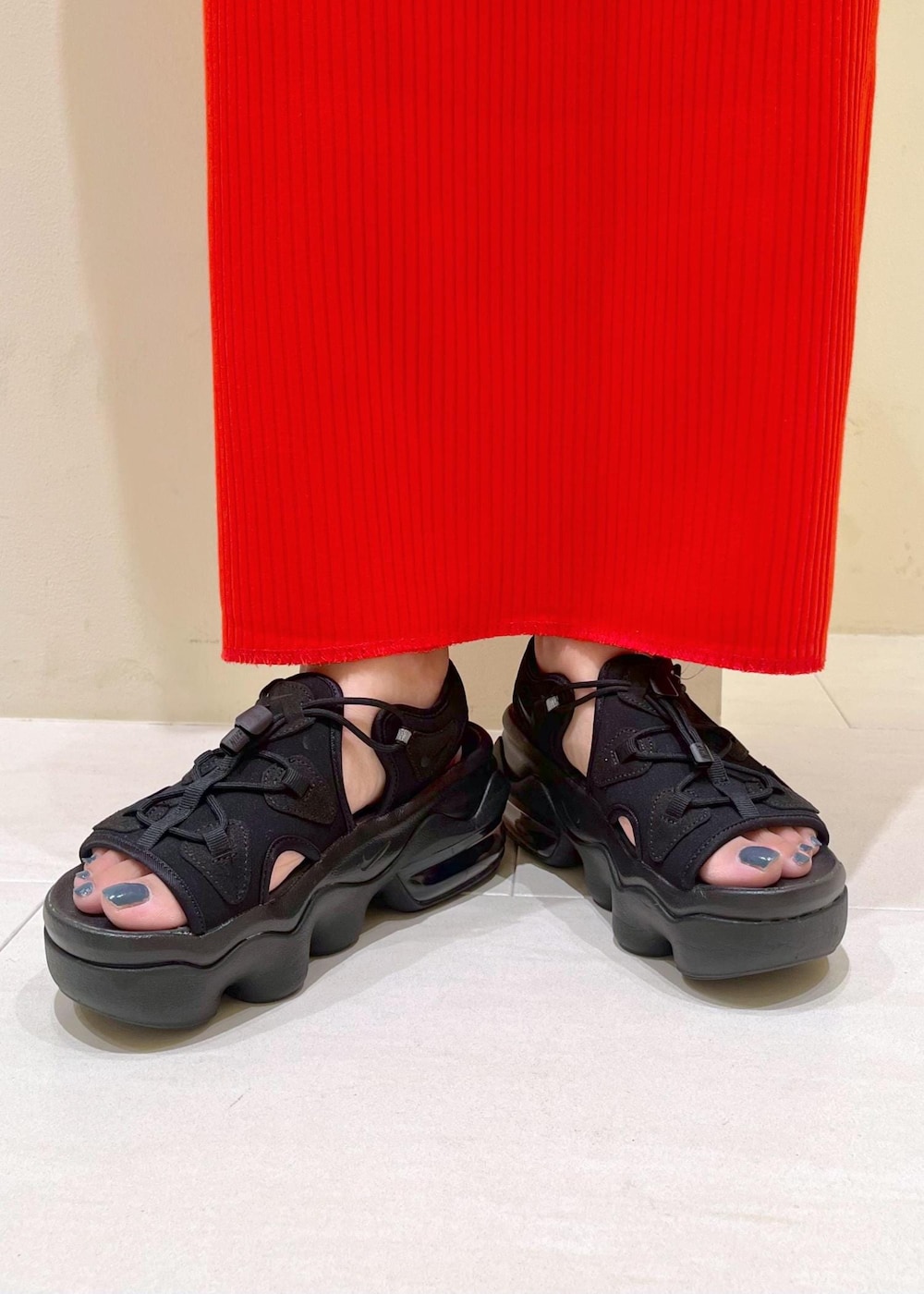 オレンジ系のスカート、ベージュ系のショルダーバッグ、ホワイト系のTシャツ/カットソーを着用したレディースの夏コーディネートの10枚目の写真