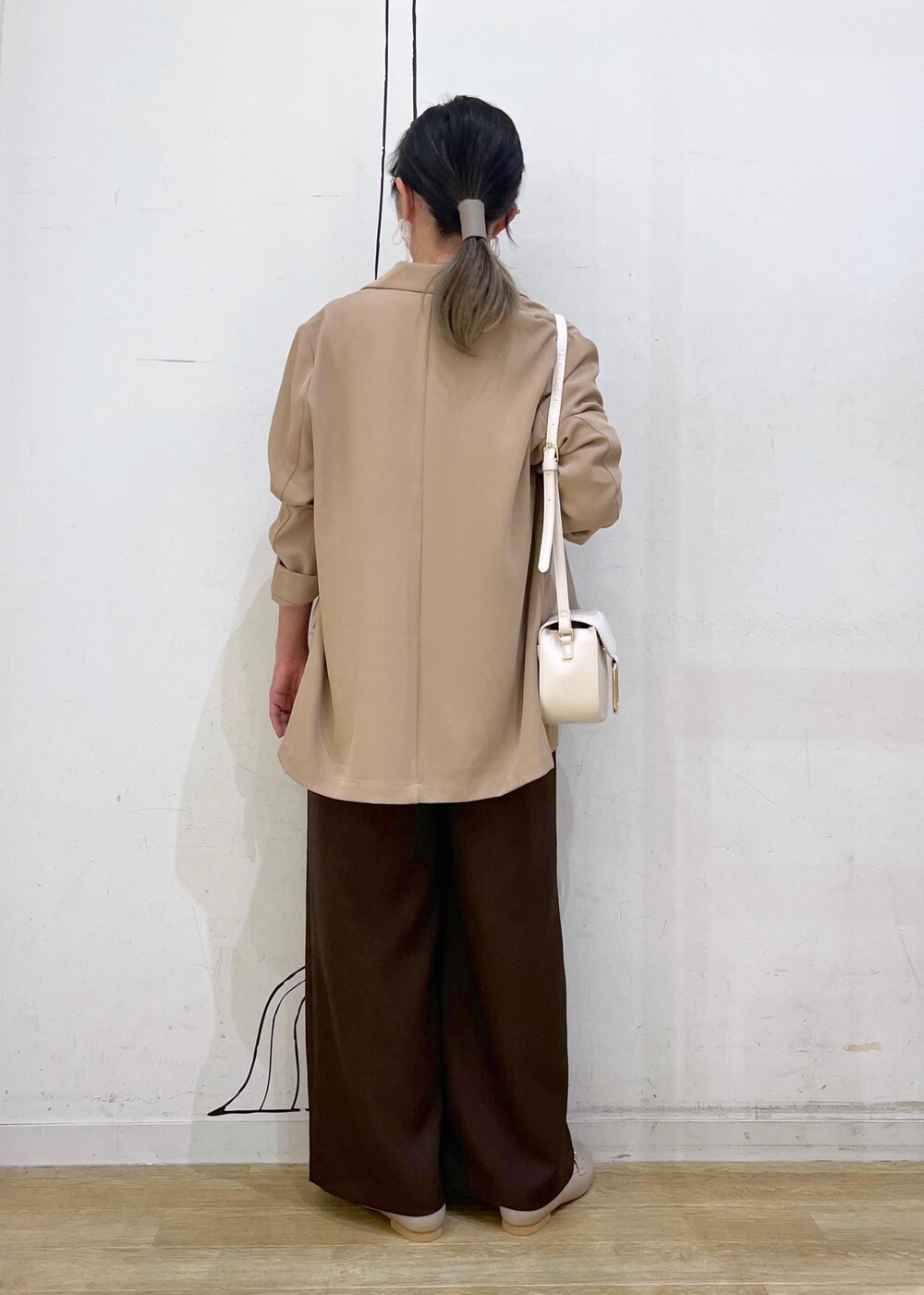 ブラック系のニット/セーター、ホワイト系のキャミソール、ベージュ系のローファーを着用したレディースの秋コーディネートの4枚目の写真