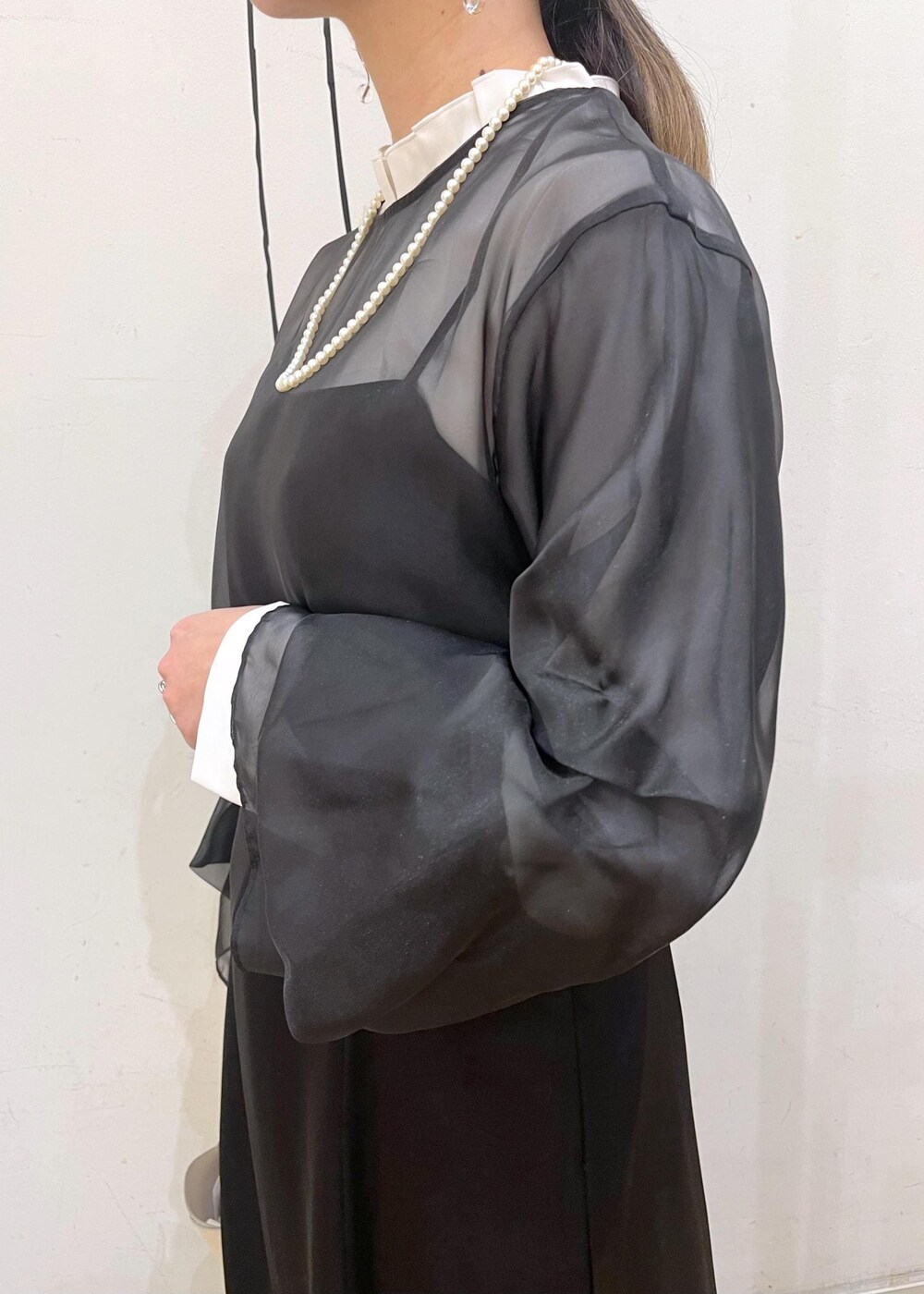 ベージュ系のローファー、ホワイト系のショルダーバッグ、ブラック系のドレスを着用したレディースの冬コーディネートの6枚目の写真