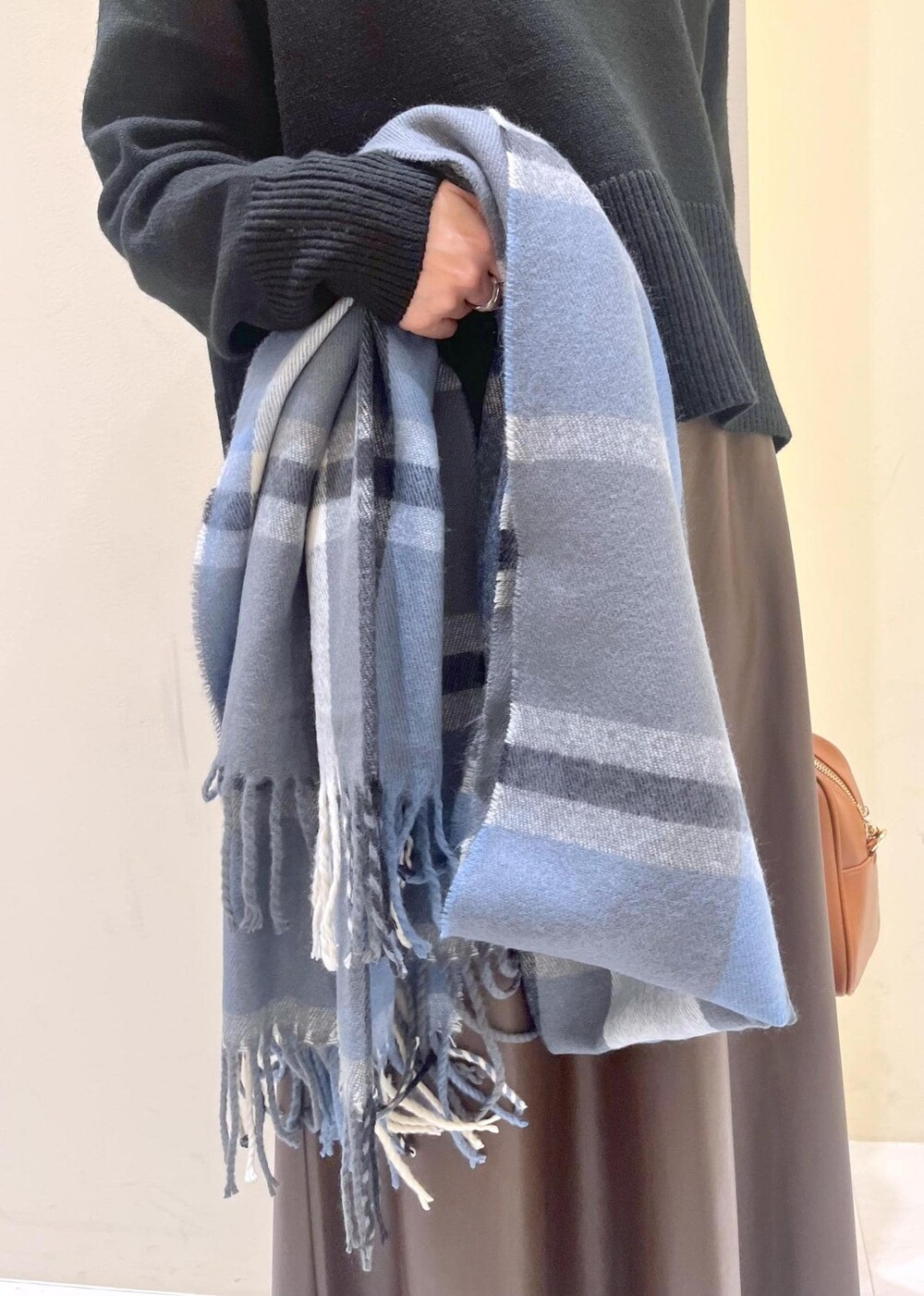 ブラウン系のスカート、ブラウン系のボストンバッグ、ブラック系のニット/セーターを着用したレディースの秋コーディネートの7枚目の写真