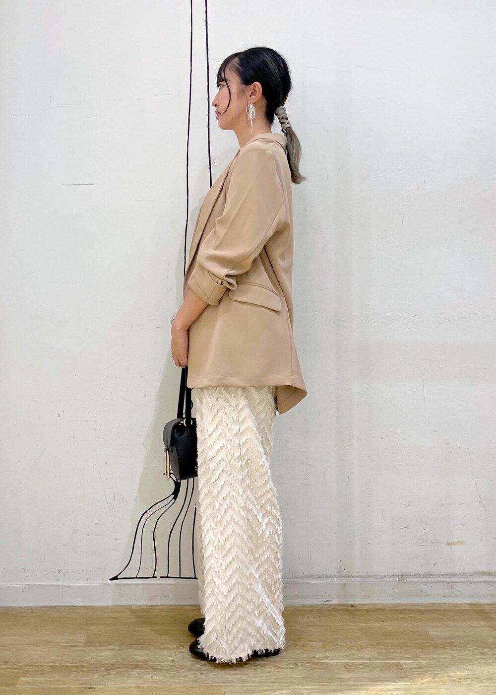 ベージュ系のタンクトップ、ブラック系のショルダーバッグ、ベージュ系のその他パンツを着用したレディースの秋コーディネートの4枚目の写真