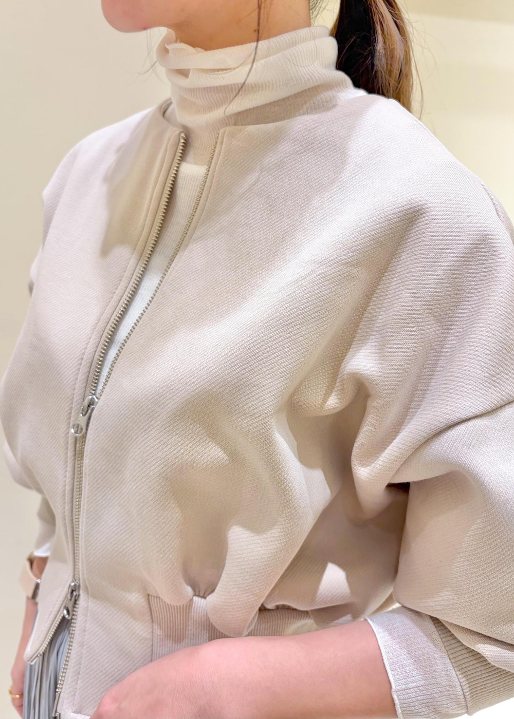 グレー系のスカート、ベージュ系のカーディガン/ボレロ、ホワイト系のトートバッグを着用したレディースの冬コーディネートの5枚目の写真