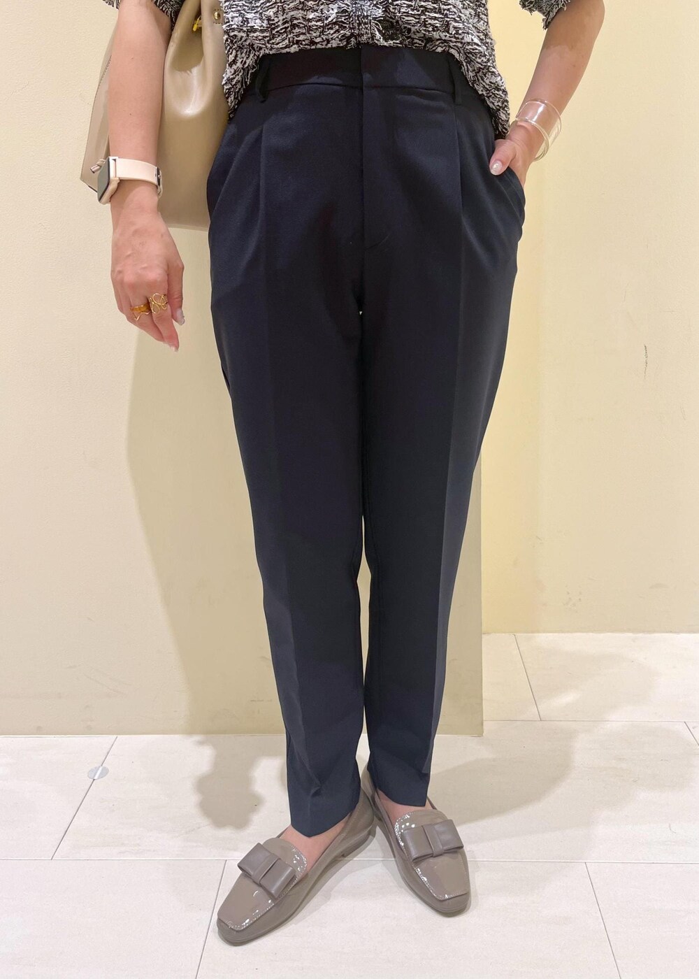 ブルー系のスラックス、ベージュ系のショルダーバッグ、ブラック系のカーディガン/ボレロを着用したレディースの夏コーディネートの8枚目の写真