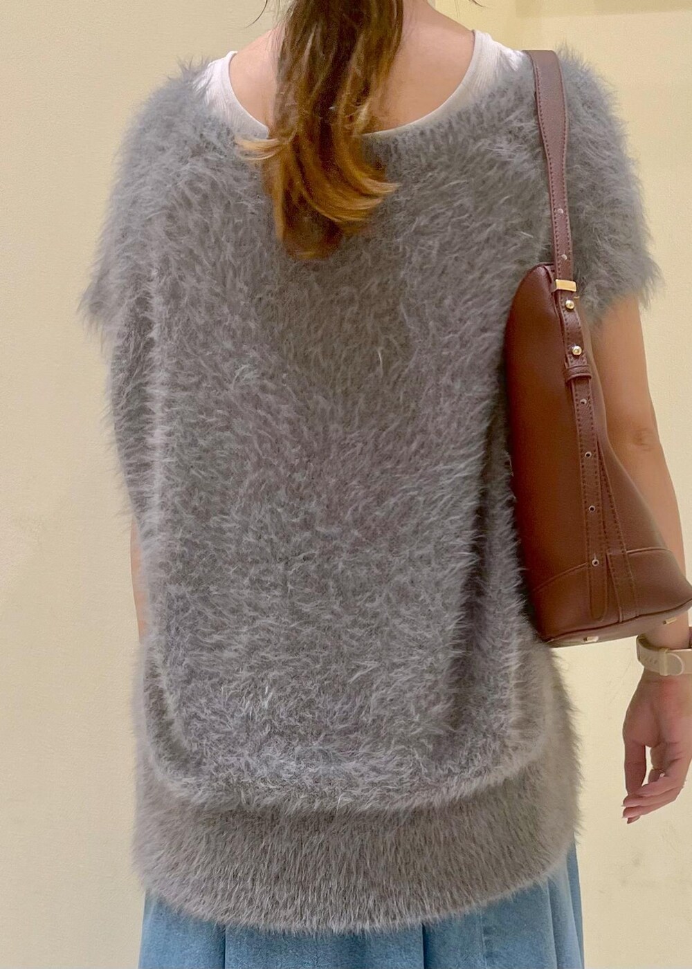 グレー系のタンクトップ、ブルー系のスカート、グレー系のベストを着用したレディースの秋コーディネートの6枚目の写真