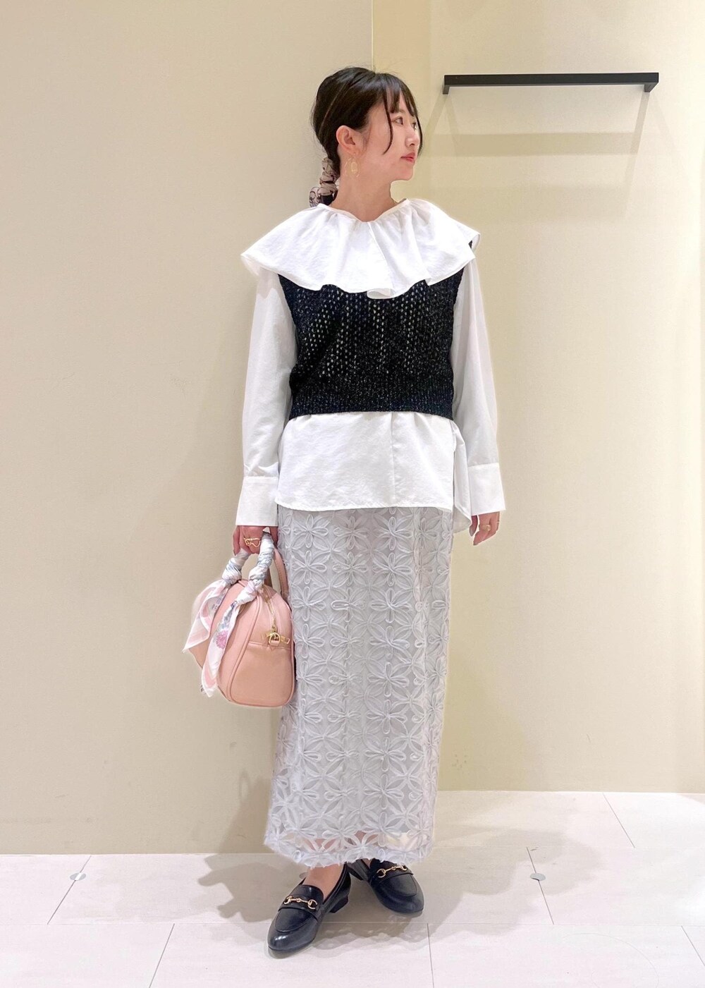 ブラック系のローファー、グレー系のスカート、ホワイト系のシャツ/ブラウスを着用したレディースの春コーディネートの2枚目の写真