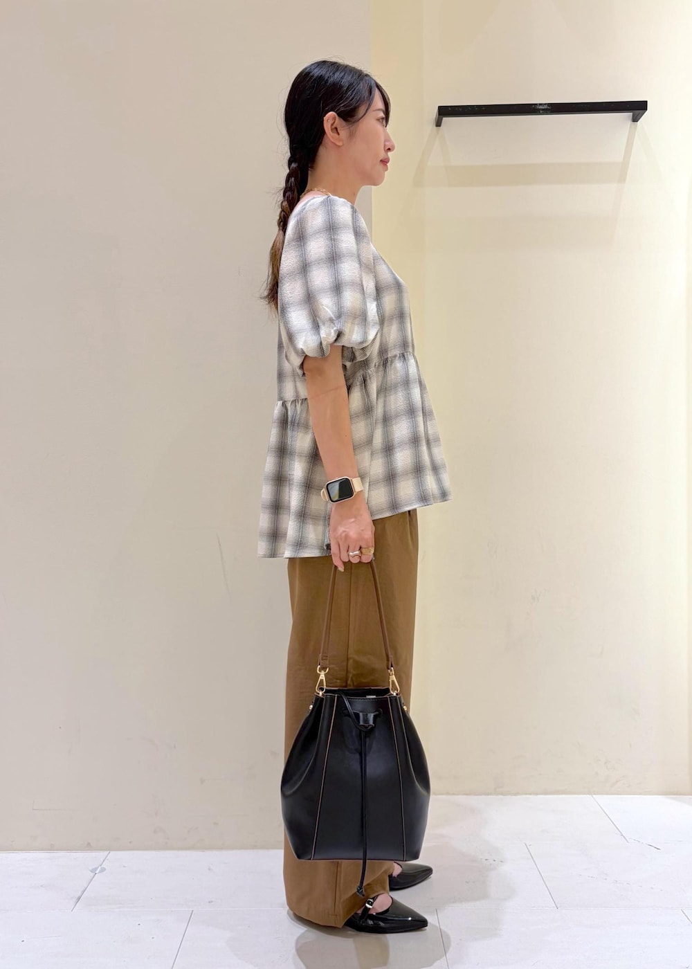 ブラック系のショルダーバッグ、ブラック系のパンプス、イエロー系のその他パンツを着用したレディースの春コーディネートの2枚目の写真