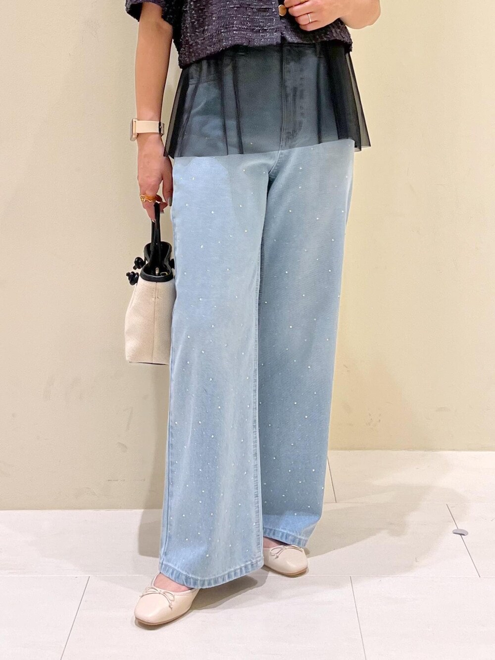 ブルー系のデニムパンツ、ホワイト系のバレエシューズ、グレー系のノーカラージャケットを着用したレディースの春コーディネートの6枚目の写真