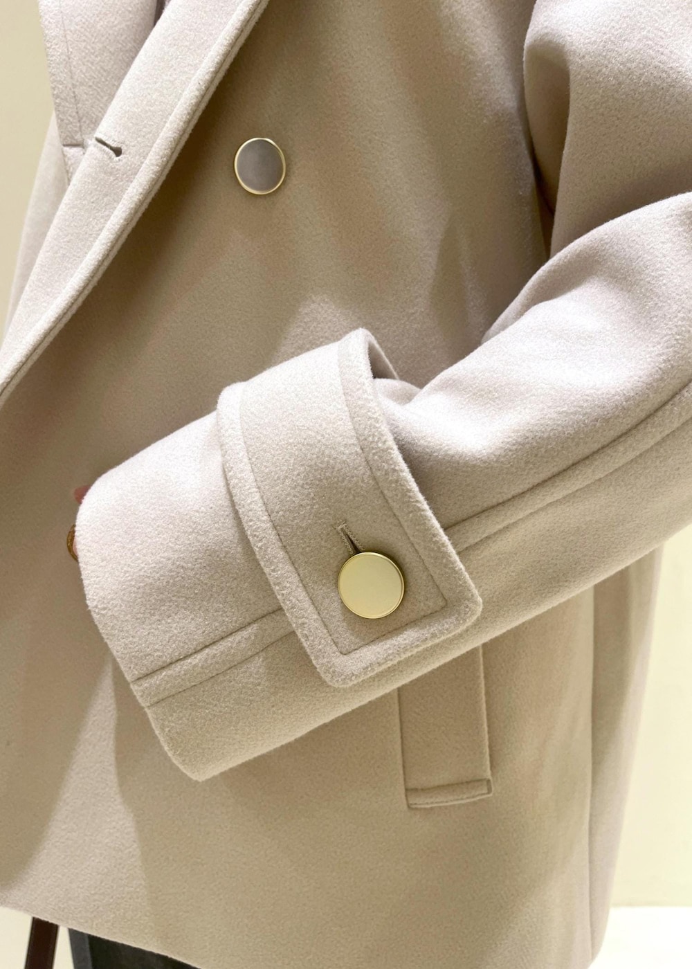 レッド系のショルダーバッグ、ホワイト系のニット/セーター、ベージュ系のその他アウターを着用したレディースの冬コーディネートの6枚目の写真