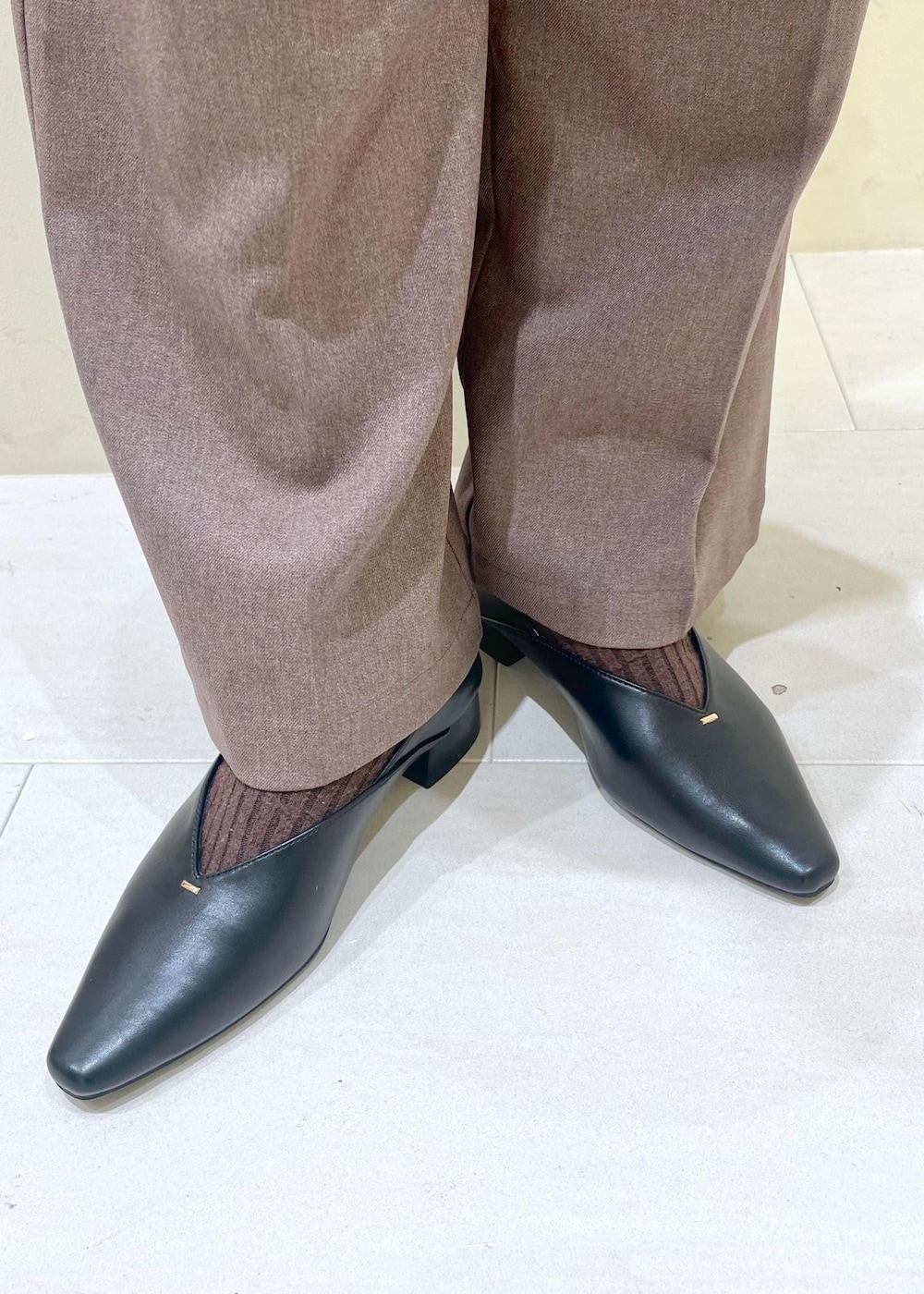 ベージュ系のスラックス、ホワイト系のニット/セーター、ベージュ系のショルダーバッグを着用したレディースの冬コーディネートの10枚目の写真