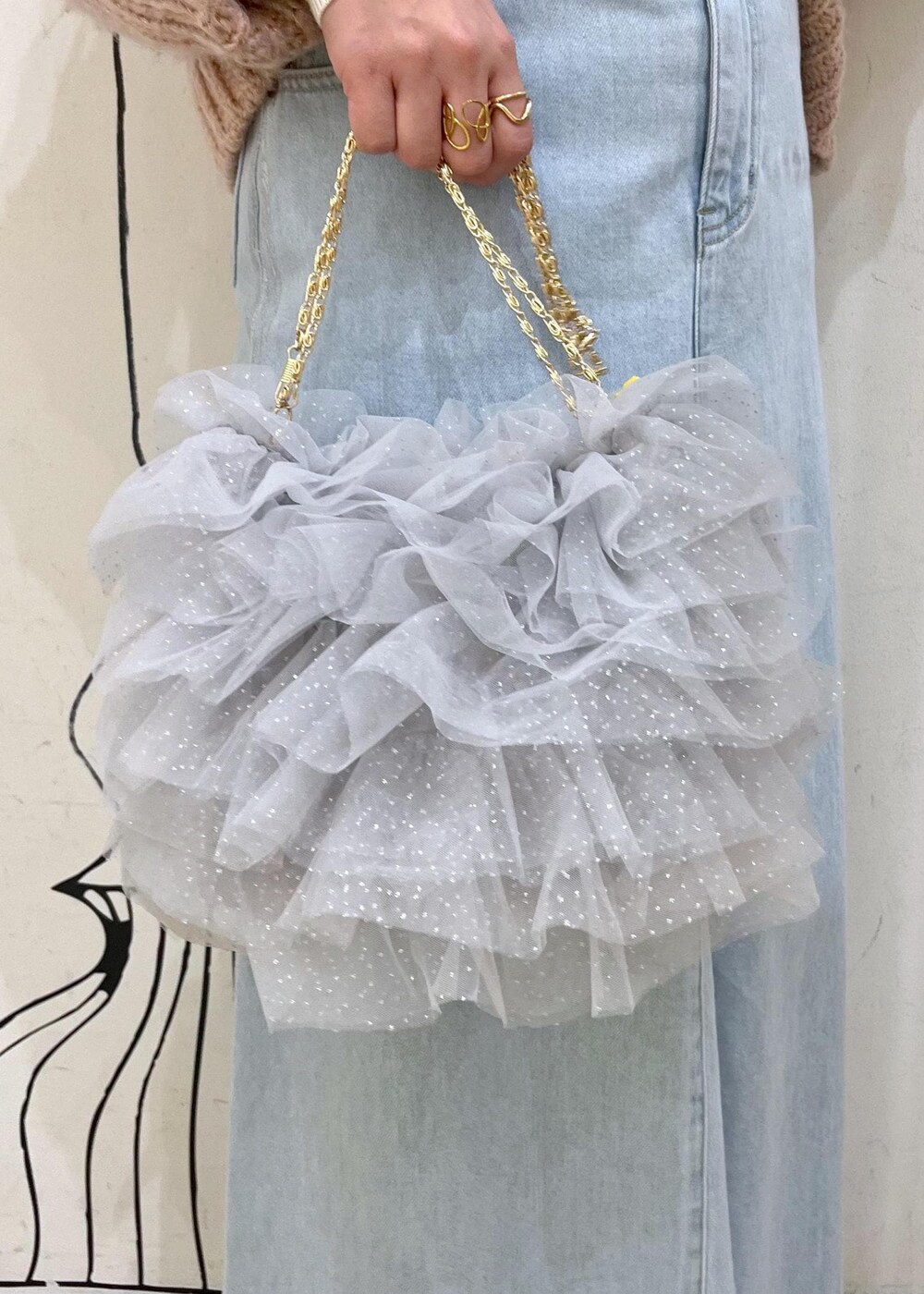 ホワイト系のニット/セーター、ブラック系のパンプス、ブルー系のデニムスカートを着用したレディースの冬コーディネートの9枚目の写真