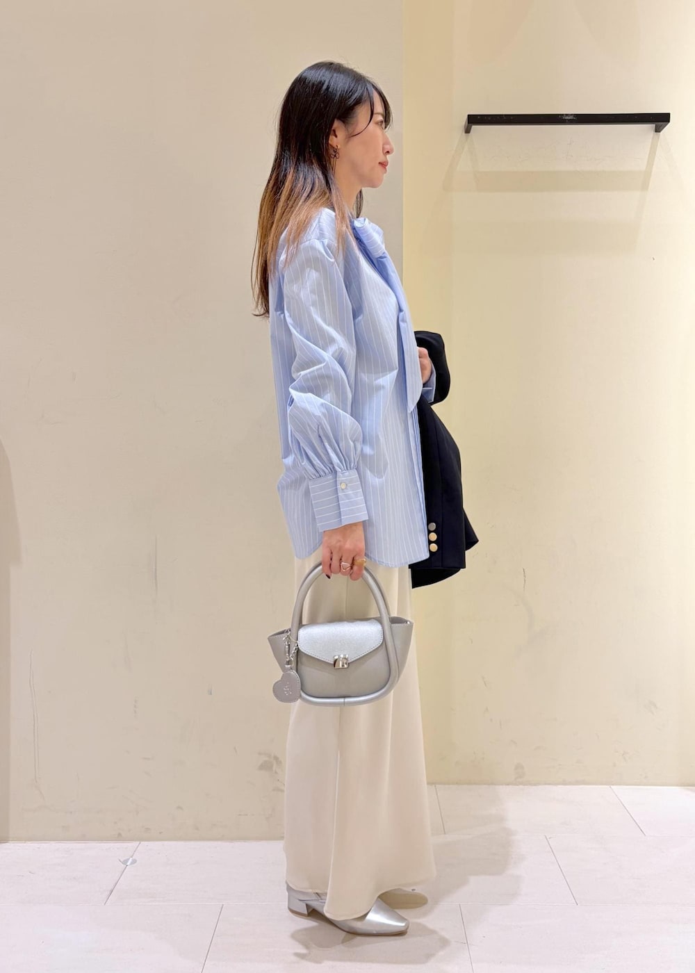 シルバー系のショルダーバッグ、ブルー系のテーラードジャケット、ブルー系のシャツ/ブラウスを着用したレディースの春コーディネートの2枚目の写真