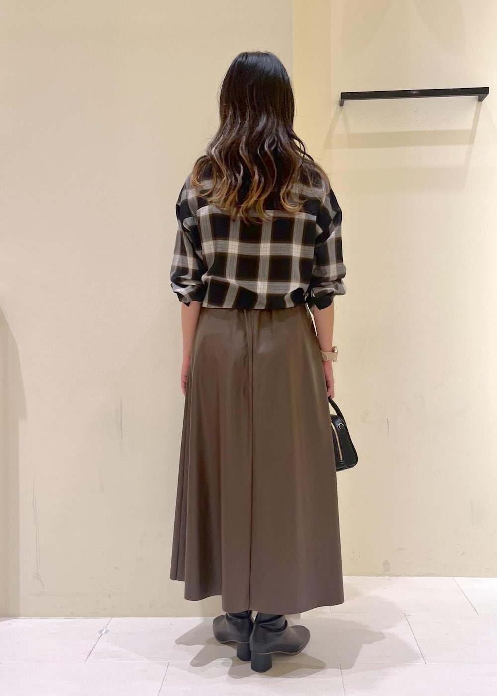 ブラック系のシャツ/ブラウス、グリーン系のスカート、ブラック系のブーツを着用したレディースの秋コーディネートの4枚目の写真