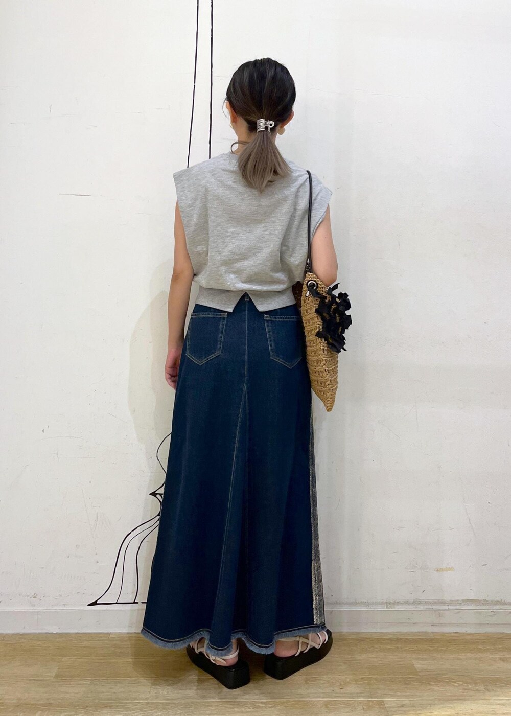 ホワイト系のサンダル、ブラック系のトートバッグ、グレー系のスウェットを着用したレディースの夏コーディネートの3枚目の写真