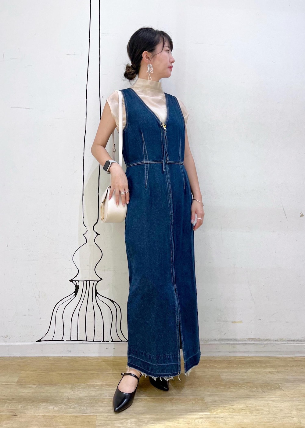 グレー系のタンクトップ、ブラック系のパンプス、ホワイト系のショルダーバッグを着用したレディースの夏コーディネートの2枚目の写真