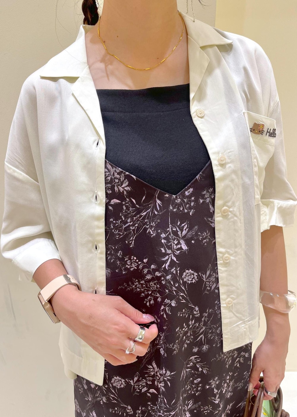 ブラウン系のトートバッグ、ゴールド系のサンダル、ブラック系のワンピースを着用したレディースの夏コーディネートの5枚目の写真