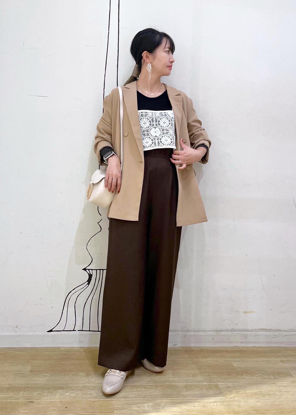 ブラック系のニット/セーター、ホワイト系のキャミソール、ベージュ系のローファーを着用したレディースの秋コーディネートの2枚目の写真