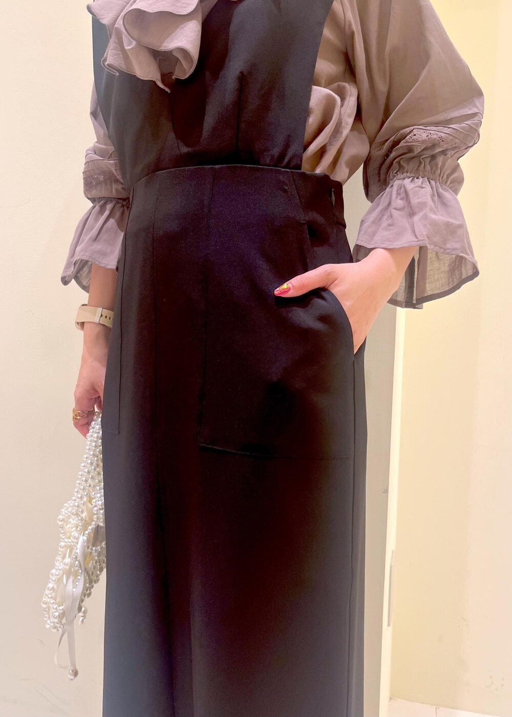 ホワイト系のバレエシューズ、ブラウン系のシャツ/ブラウス、ブラック系のジャンパースカートを着用したレディースの春コーディネートの8枚目の写真