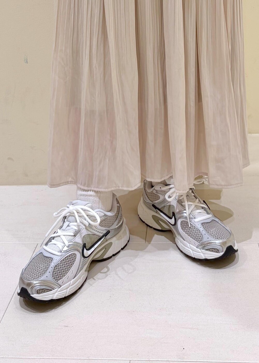 ホワイト系のスウェット、ブルー系のシャツ/ブラウス、ベージュ系のスカートを着用したレディースの冬コーディネートの9枚目の写真