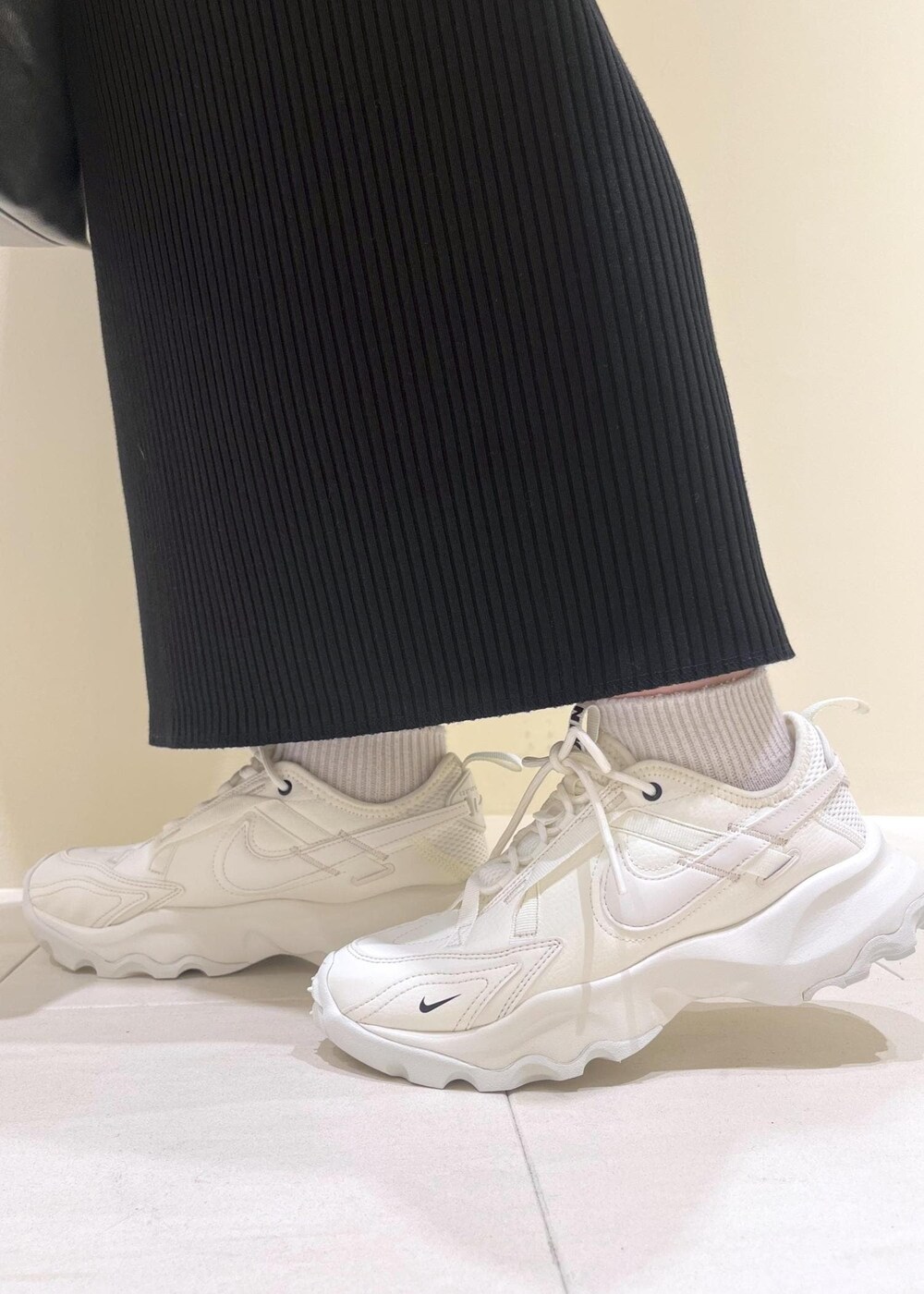 シルバー系のトートバッグ、ブラック系のスカート、ブルー系のシャツ/ブラウスを着用したレディースの春コーディネートの10枚目の写真