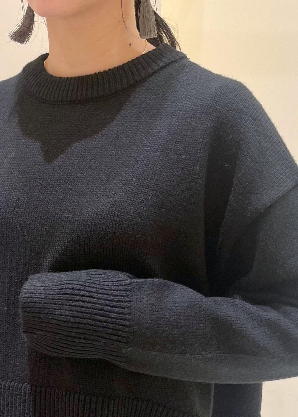 ブラウン系のスカート、ブラウン系のボストンバッグ、ブラック系のニット/セーターを着用したレディースの秋コーディネートの5枚目の写真