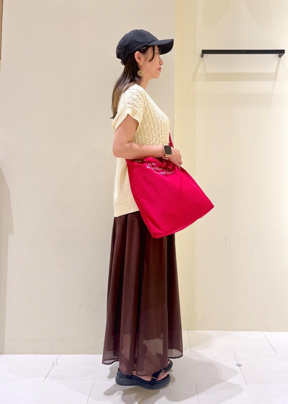 ブラック系のサンダル、ブラウン系のスカート、ベージュ系のベストを着用したレディースの夏コーディネートの3枚目の写真