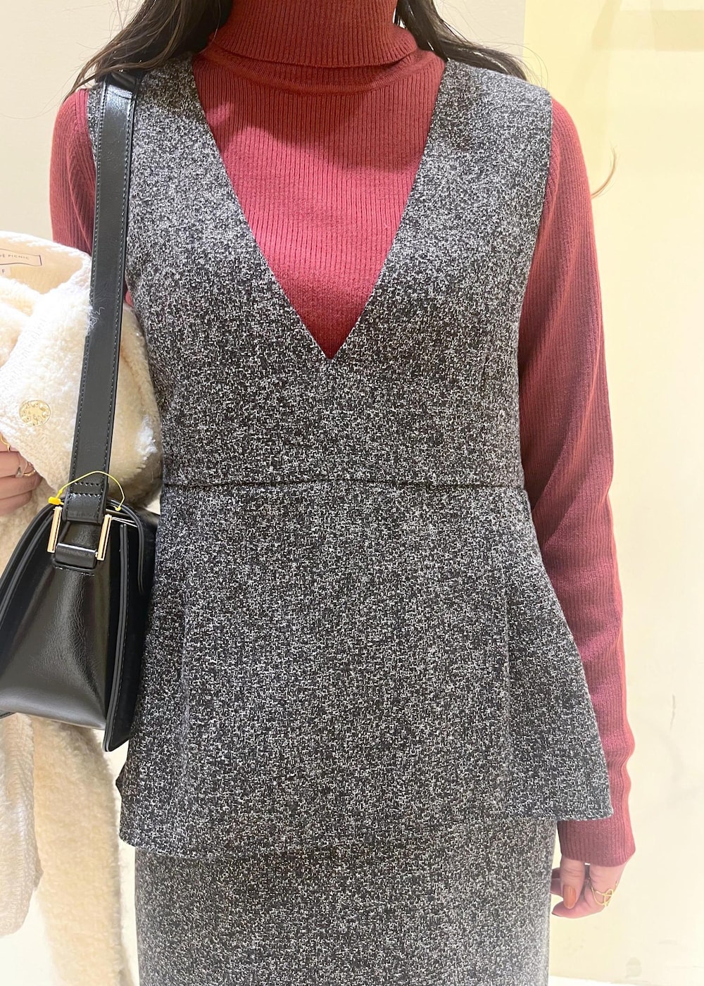 ブラック系のショルダーバッグ、ホワイト系のカーディガン/ボレロ、レッド系のニット/セーターを着用したレディースの秋コーディネートの10枚目の写真